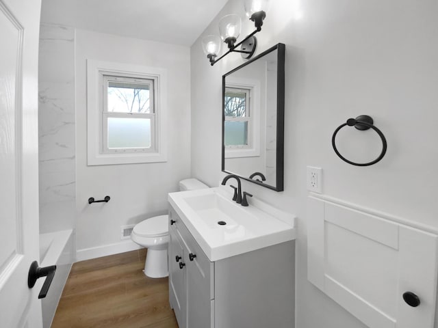 11601 Wren St NW, Coon Rapids, MN 55433 - bathroom with vanity, toilet, a bathtub, wood finished floors, and a shower