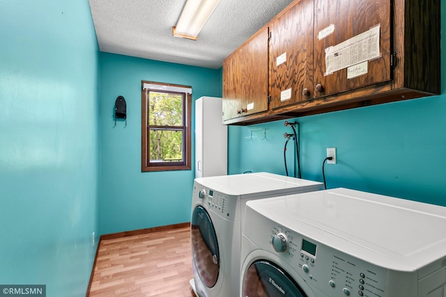 19405 Parkview Ave N, Scandia, MN 55073 - laundry room with cabinet space, washing machine and dryer, a textured ceiling, and light wood-style floors