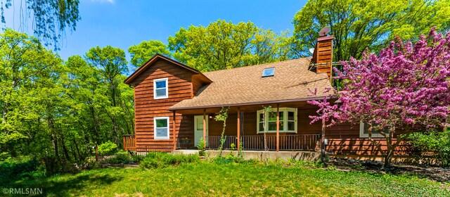 19405 Parkview Ave N, Scandia, MN 55073 - chalet / cabin featuring a porch, roof with shingles, and a chimney