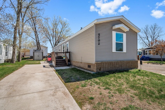 5702 Cabot Dr, Mounds View, MN 55112 - view of home's exterior featuring an outdoor structure, crawl space, a shed, and a lawn