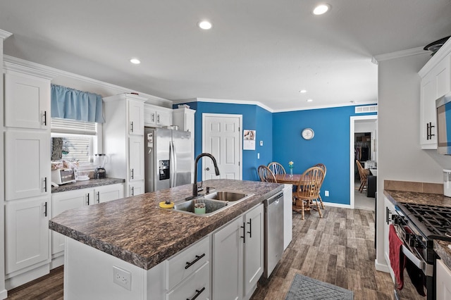 5702 Cabot Dr, Mounds View, MN 55112 - kitchen featuring a kitchen island with sink, stainless steel appliances, dark countertops, and a sink