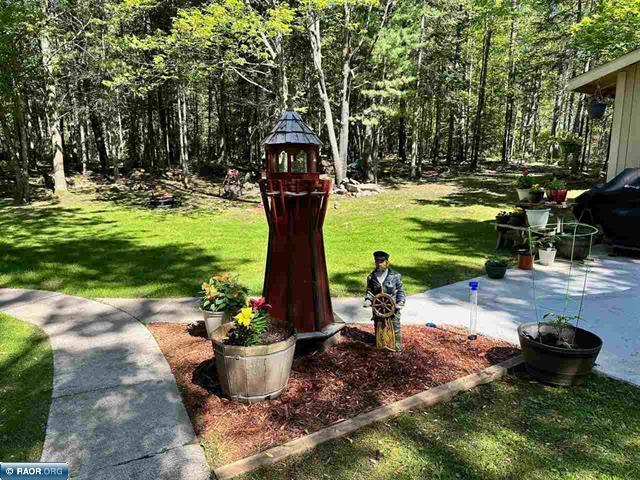 view of yard with a wooded view and a patio