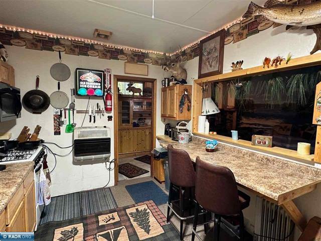 kitchen featuring light countertops, range with gas stovetop, and heating unit