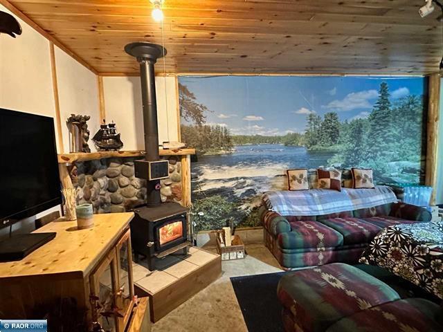 interior space featuring wooden ceiling and a wood stove