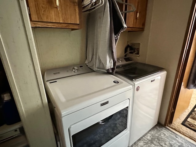 laundry area with separate washer and dryer and cabinet space