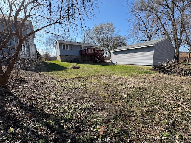 view of yard featuring an outdoor structure, stairs, and a deck