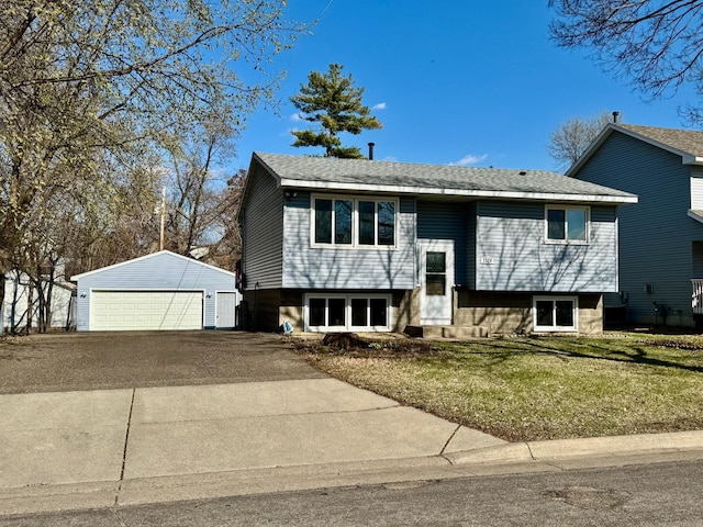 split foyer home featuring a detached garage, an outbuilding, and a front lawn