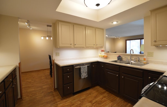 kitchen featuring light countertops, dark brown cabinets, dishwasher, track lighting, and a sink