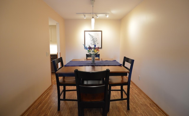 dining space featuring baseboards and wood finished floors