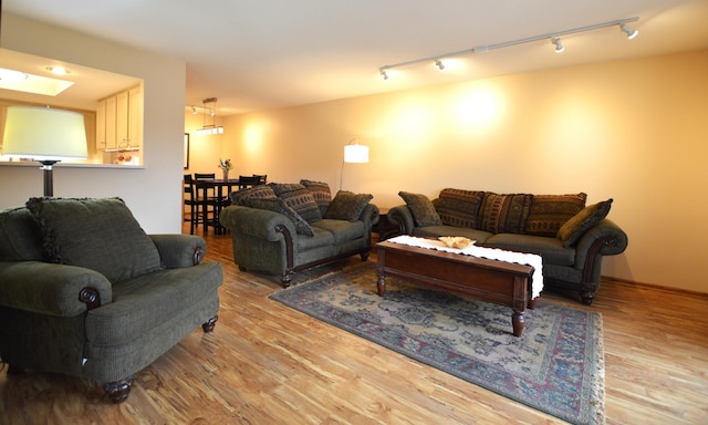 living area with track lighting and wood finished floors