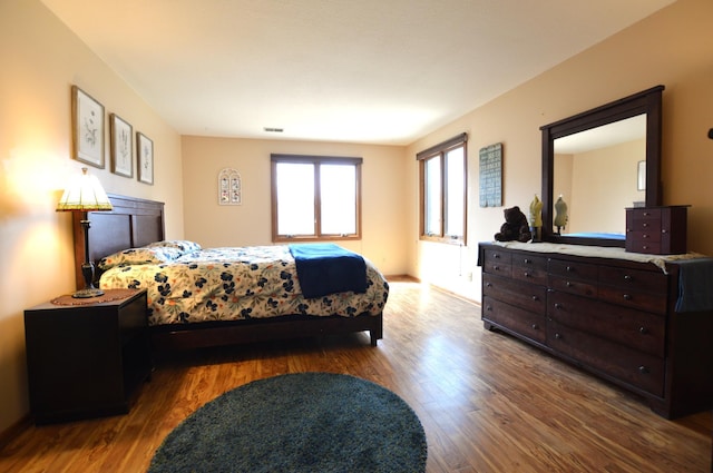 bedroom featuring wood finished floors and visible vents