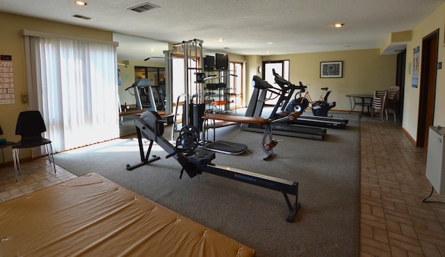 workout room with recessed lighting, brick floor, visible vents, and baseboards
