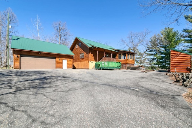 2746 Swift Ln NW, Hackensack, MN 56452 - view of front of home with a detached garage, metal roof, an outbuilding, and log veneer siding