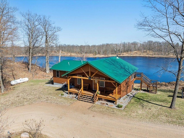 log home with covered porch, a water view, and metal roof