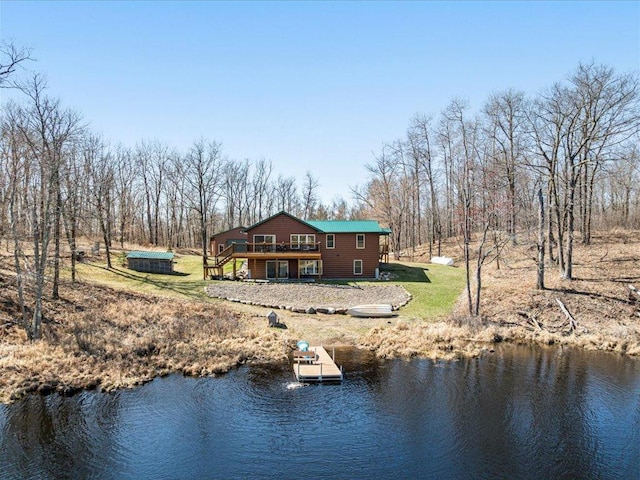 exterior space featuring a lawn and a deck with water view
