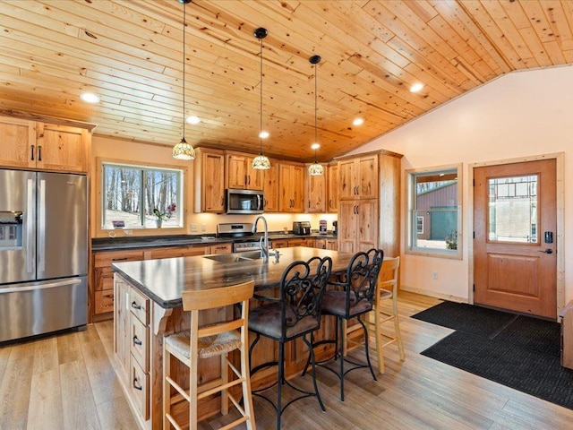 kitchen with wood ceiling, plenty of natural light, dark countertops, a sink, and stainless steel appliances