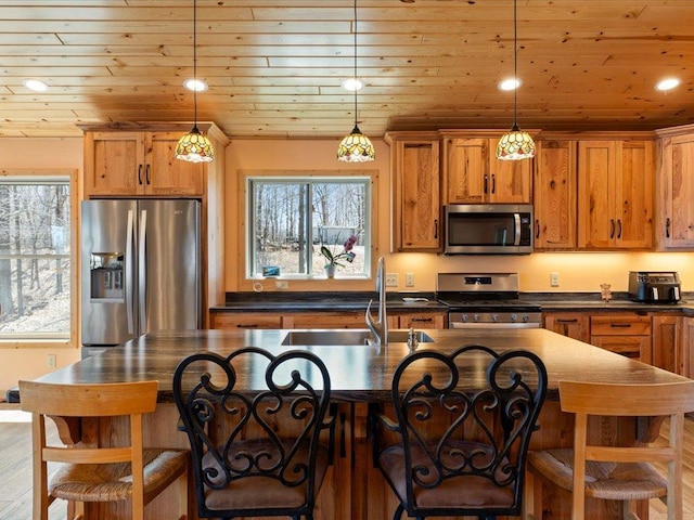 kitchen featuring wood ceiling, appliances with stainless steel finishes, a healthy amount of sunlight, and dark countertops
