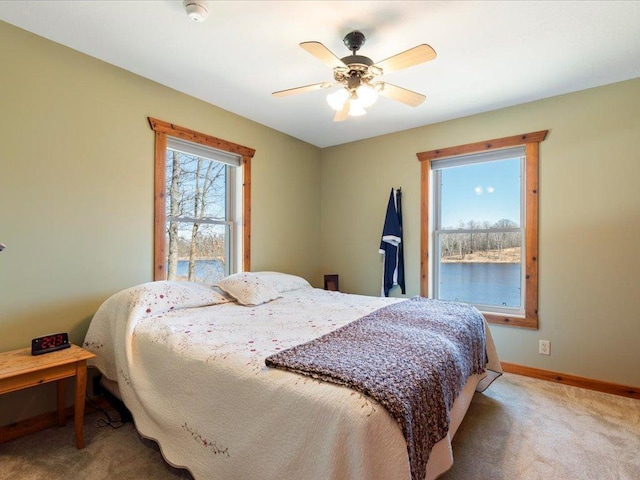 carpeted bedroom featuring baseboards and ceiling fan