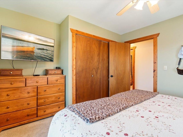 bedroom featuring ceiling fan, light carpet, and a closet