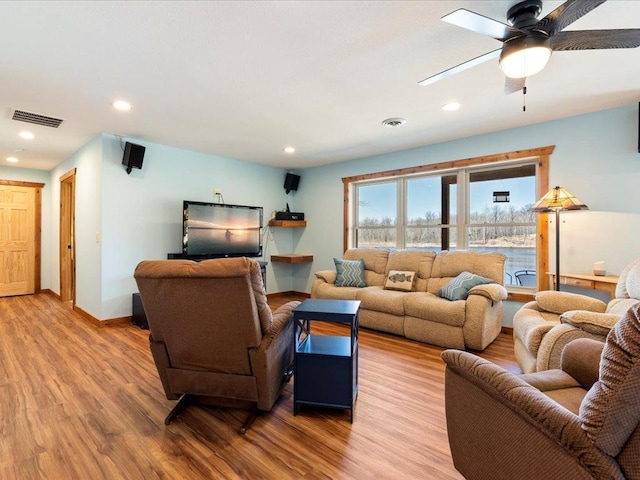 living room featuring ceiling fan, visible vents, wood finished floors, baseboards, and recessed lighting