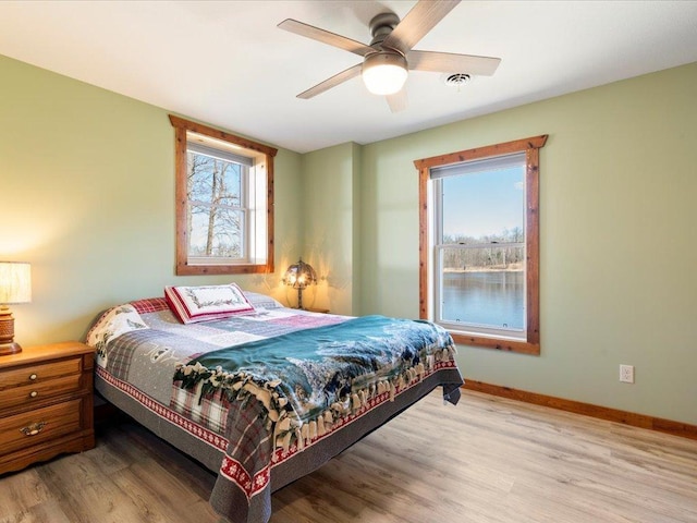 bedroom featuring baseboards, ceiling fan, and light wood-style flooring