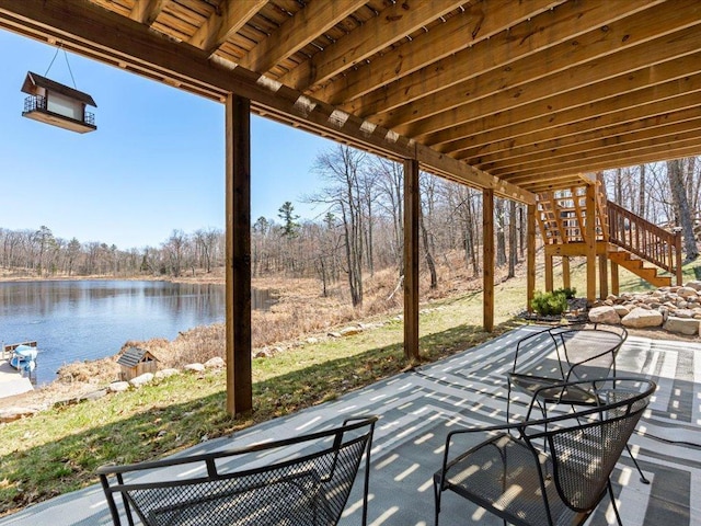 view of patio / terrace featuring stairway and a water view