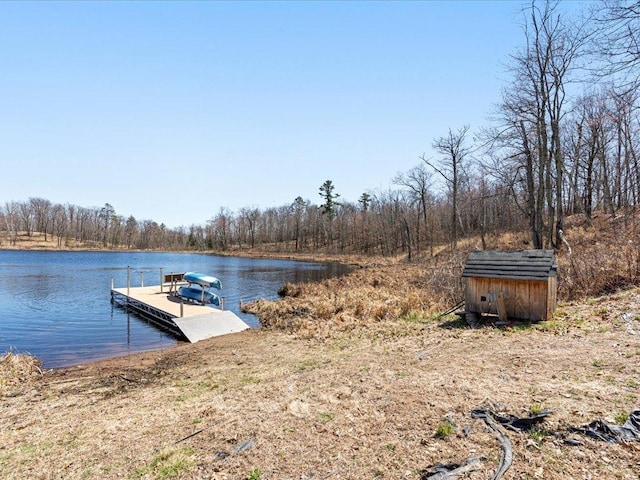 view of dock with a water view and a wooded view