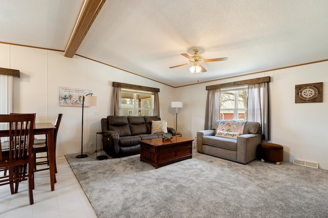 living area featuring visible vents, lofted ceiling with beams, a ceiling fan, and a textured ceiling