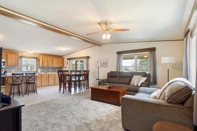 living room with a ceiling fan and vaulted ceiling with beams