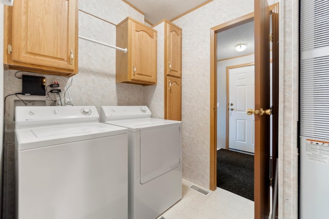 laundry area with cabinet space, washing machine and clothes dryer, a heating unit, visible vents, and a textured ceiling