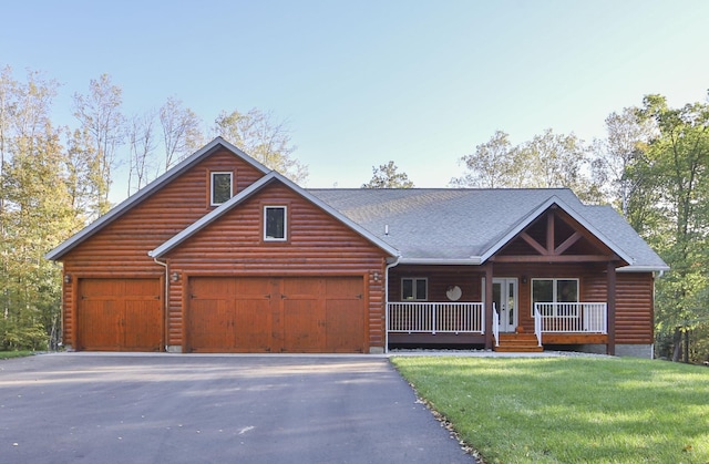 view of front of home featuring faux log siding, roof with shingles, a porch, a front yard, and aphalt driveway