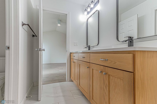 3463 Loberg Dr, West Fargo, ND 58078 - bathroom with toilet, vanity, marble finish flooring, baseboards, and lofted ceiling