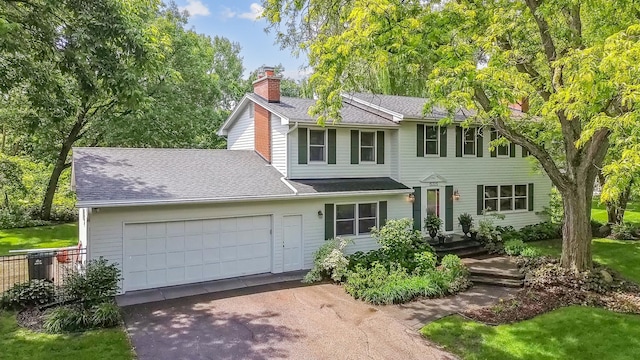 15325 Holdridge Dr E, Minnetonka, MN 55391 - view of front of property featuring a chimney, driveway, an attached garage, and roof with shingles