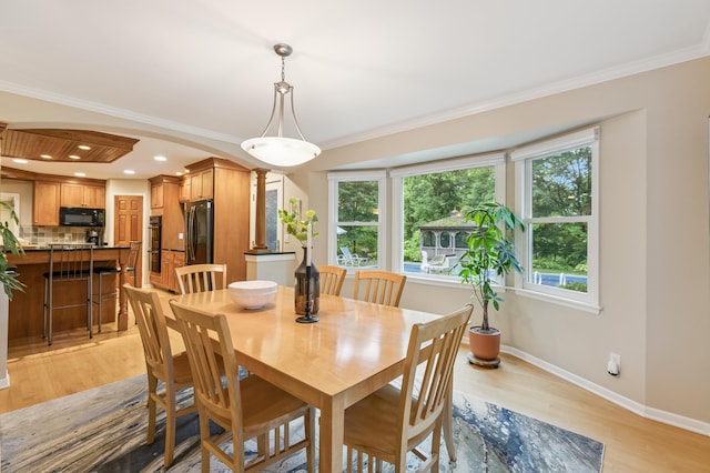 15325 Holdridge Dr E, Minnetonka, MN 55391 - dining area featuring decorative columns, light wood-type flooring, crown molding, arched walkways, and recessed lighting