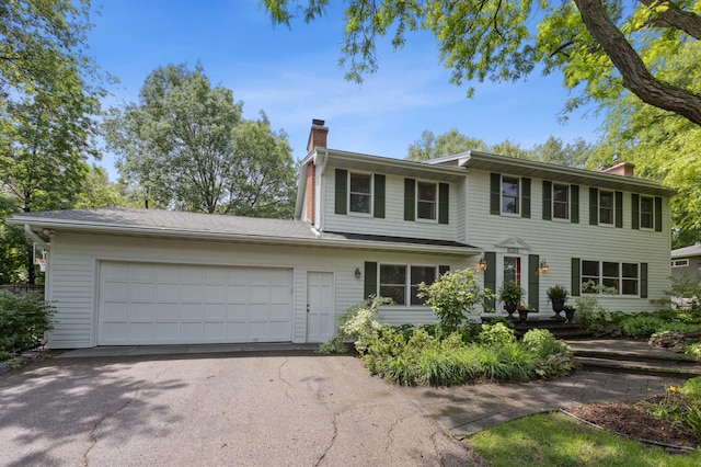 15325 Holdridge Dr E, Minnetonka, MN 55391 - view of front facade featuring a chimney, an attached garage, and driveway