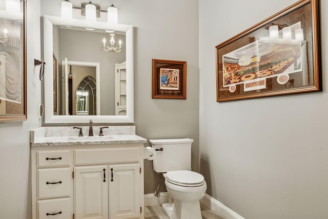 5320 132nd St W, Apple Valley, MN 55124 - bathroom with toilet, a chandelier, vanity, and baseboards