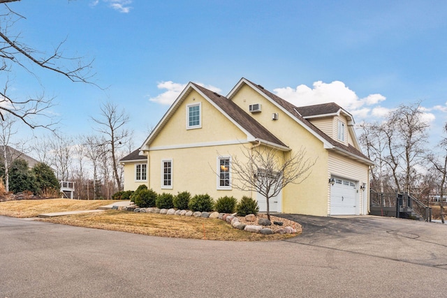 5320 132nd St W, Apple Valley, MN 55124 - view of side of home with an attached garage, driveway, stucco siding, and fence