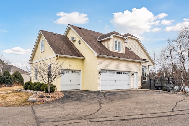 5320 132nd St W, Apple Valley, MN 55124 - view of side of home with roof with shingles, stucco siding, driveway, and an attached garage