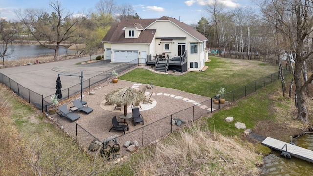 5320 132nd St W, Apple Valley, MN 55124 - rear view of house with a deck with water view, a yard, aphalt driveway, and a fenced backyard