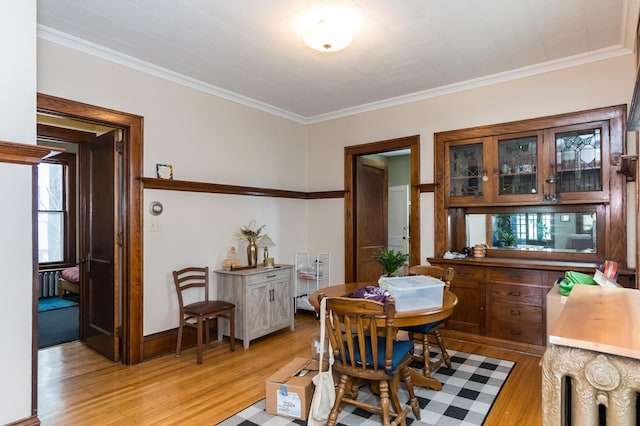 dining area featuring crown molding and light wood-type flooring