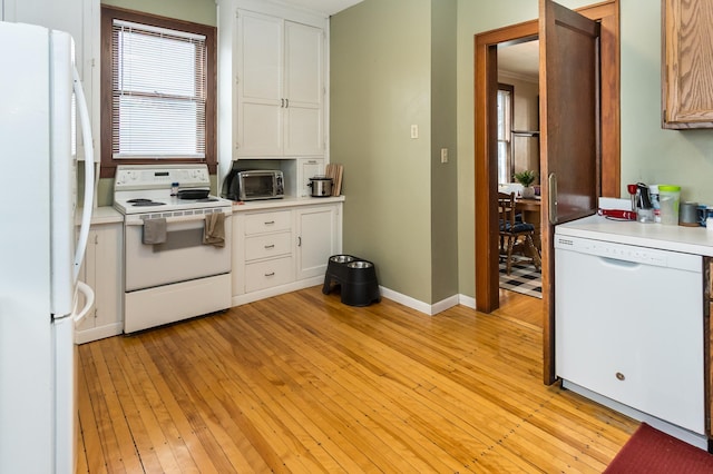kitchen featuring white cabinets, light wood-style floors, white appliances, and light countertops
