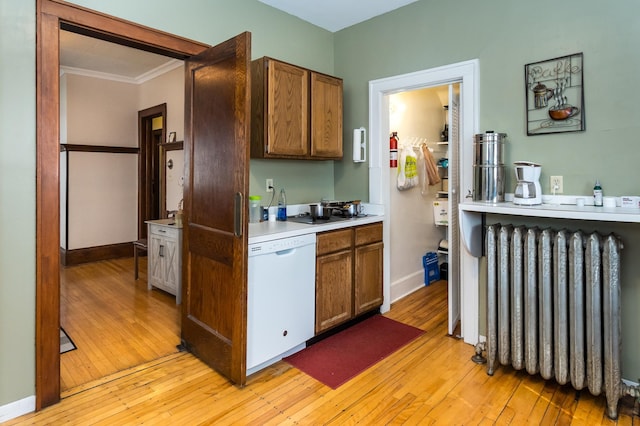 kitchen featuring radiator, dishwasher, ornamental molding, and light wood-style flooring