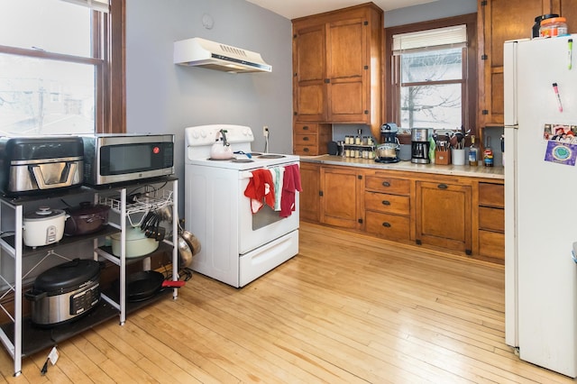 kitchen featuring light wood-style flooring, white appliances, brown cabinets, light countertops, and under cabinet range hood