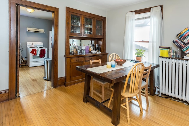 dining space featuring light wood-style floors and radiator