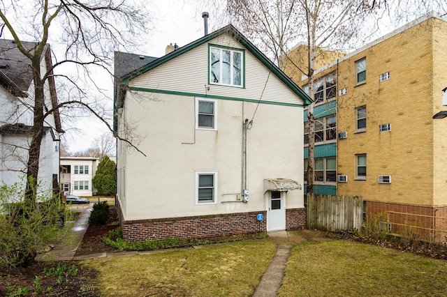 rear view of house with fence and stucco siding