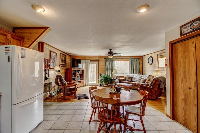 6775 State 87 SW, Backus, MN 56435 - dining room featuring a textured ceiling, ceiling fan, wood walls, and light tile patterned flooring