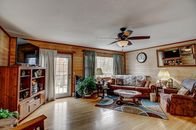 6775 State 87 SW, Backus, MN 56435 - living room featuring wood-type flooring, wood walls, a ceiling fan, and crown molding