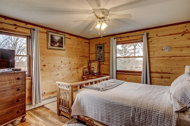 6775 State 87 SW, Backus, MN 56435 - bedroom featuring wood walls, baseboard heating, and light wood finished floors
