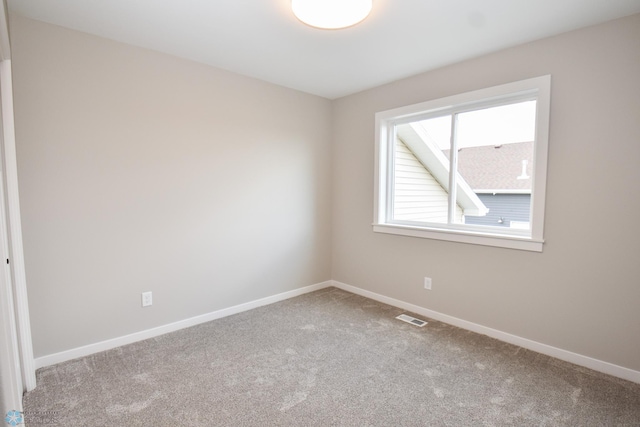 unfurnished room featuring carpet and baseboards
