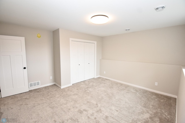 unfurnished bedroom featuring carpet floors, a closet, and baseboards